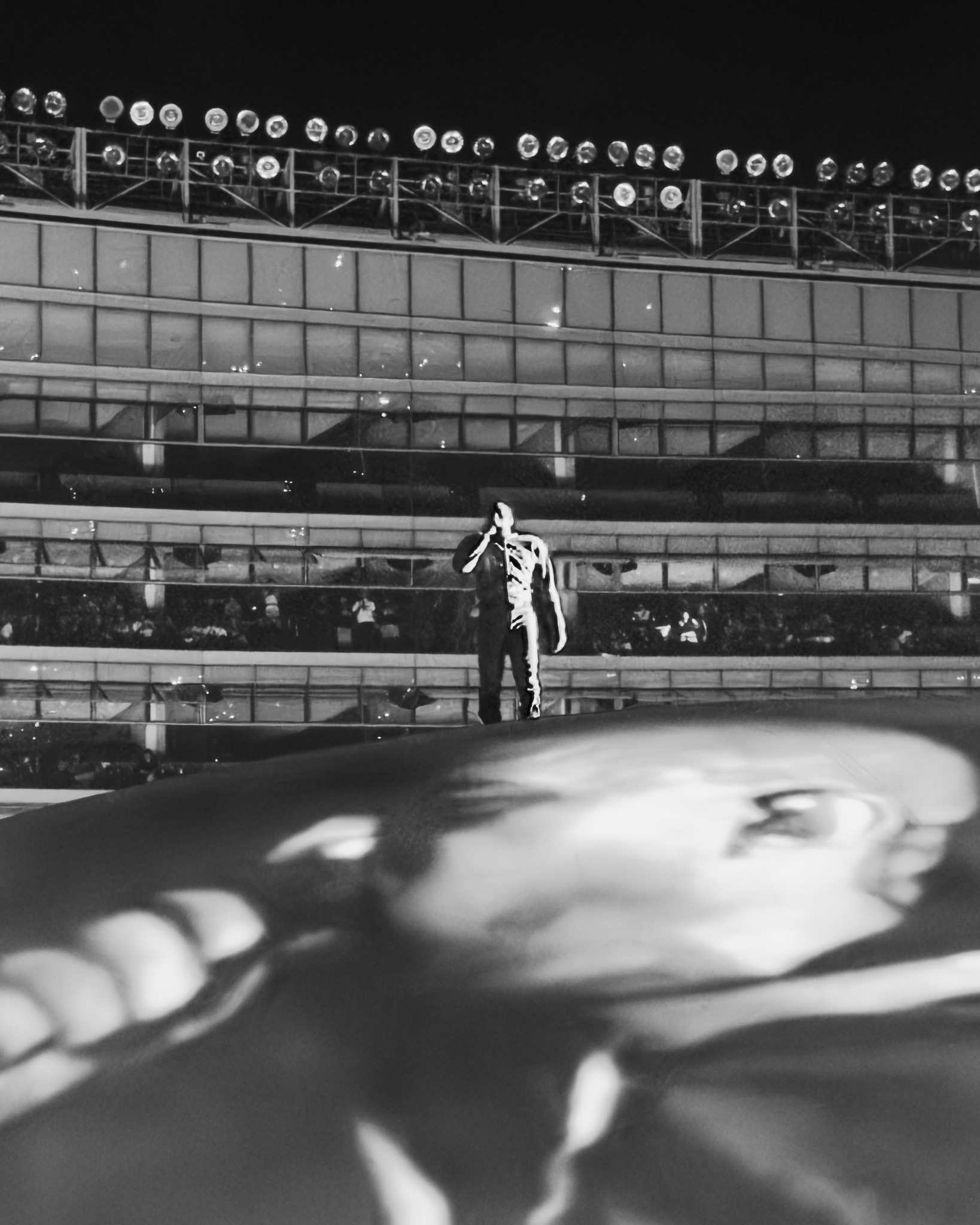 Black-and-white performance above a projected portrait