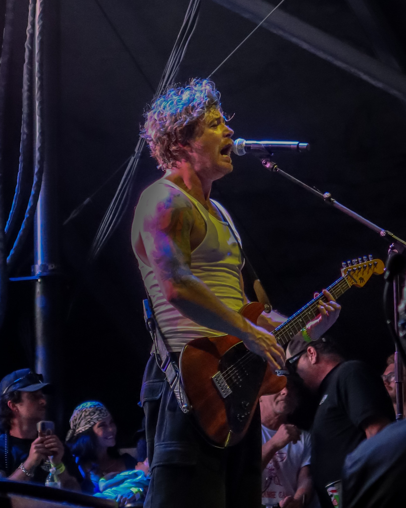 Guitarist singing under blue stage light